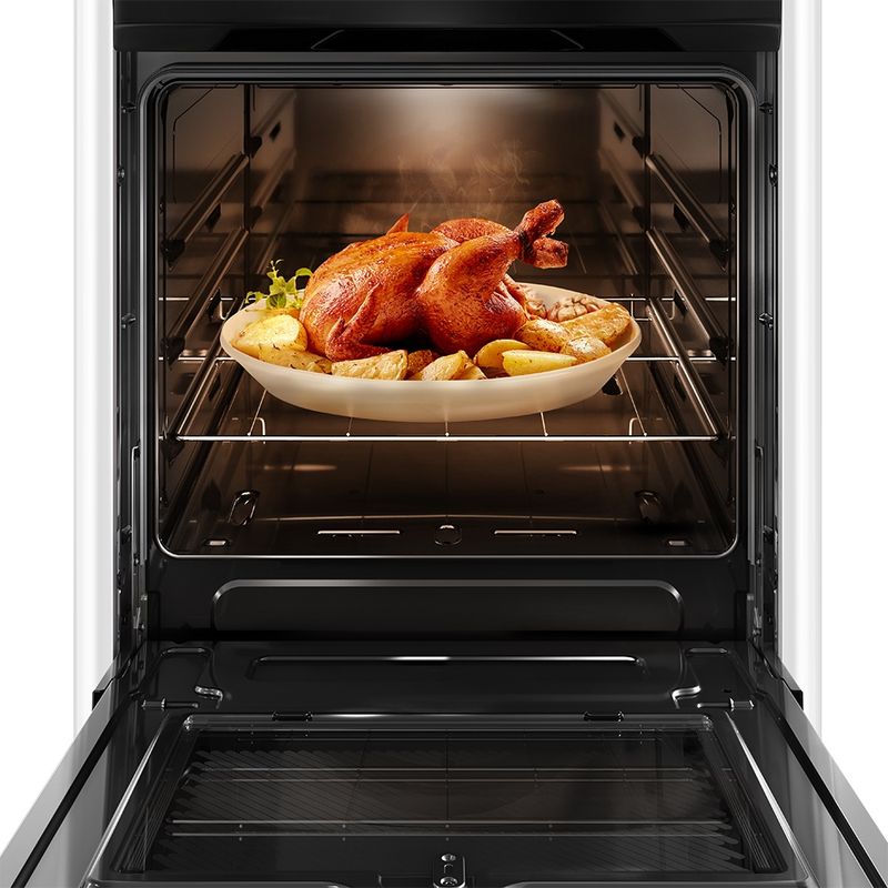 Foto frontal do fogão 4 bocas Continental branco automático com mesa compartimentada, modelo FC4CB – bivolt com a porta do forno aberta. Dentro dele, há uma luz interna na parte de cima e um frango assado com batatas em um refratário de vidro que está em cima de uma prateleira feita de grades, ela é removível e regulável em três alturas diferentes.